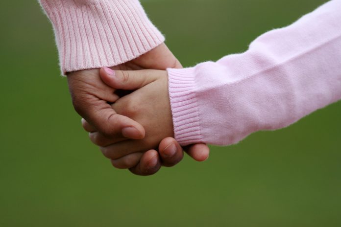 Mother and daughter holding hands while walking together
